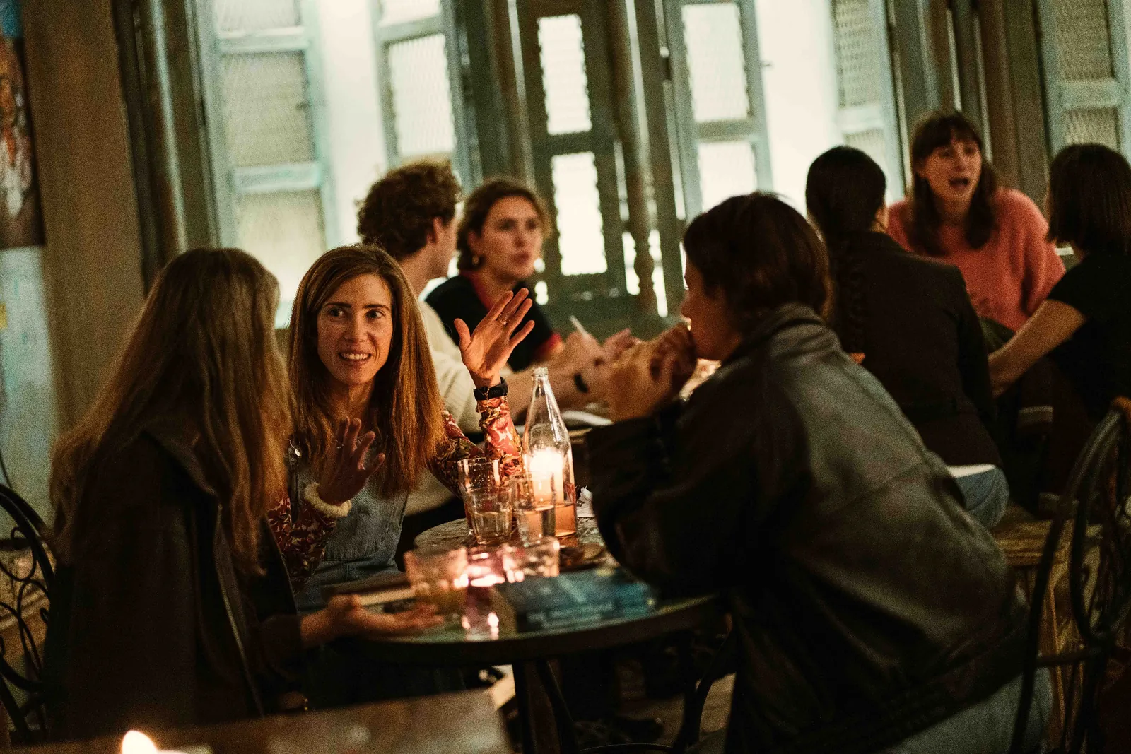 Participants talk around a candlelit table.