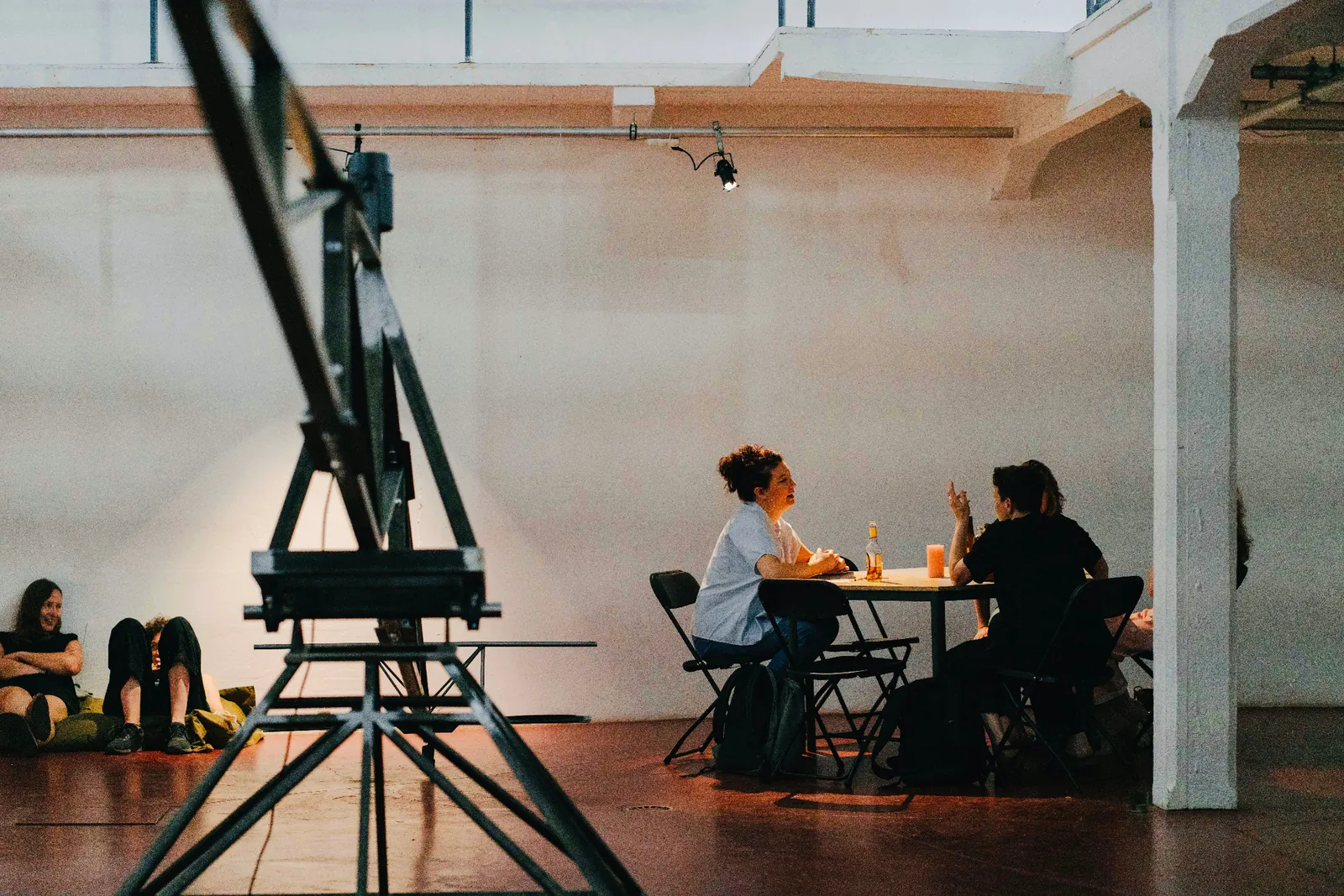 People gather around tables in a bright cultural space.