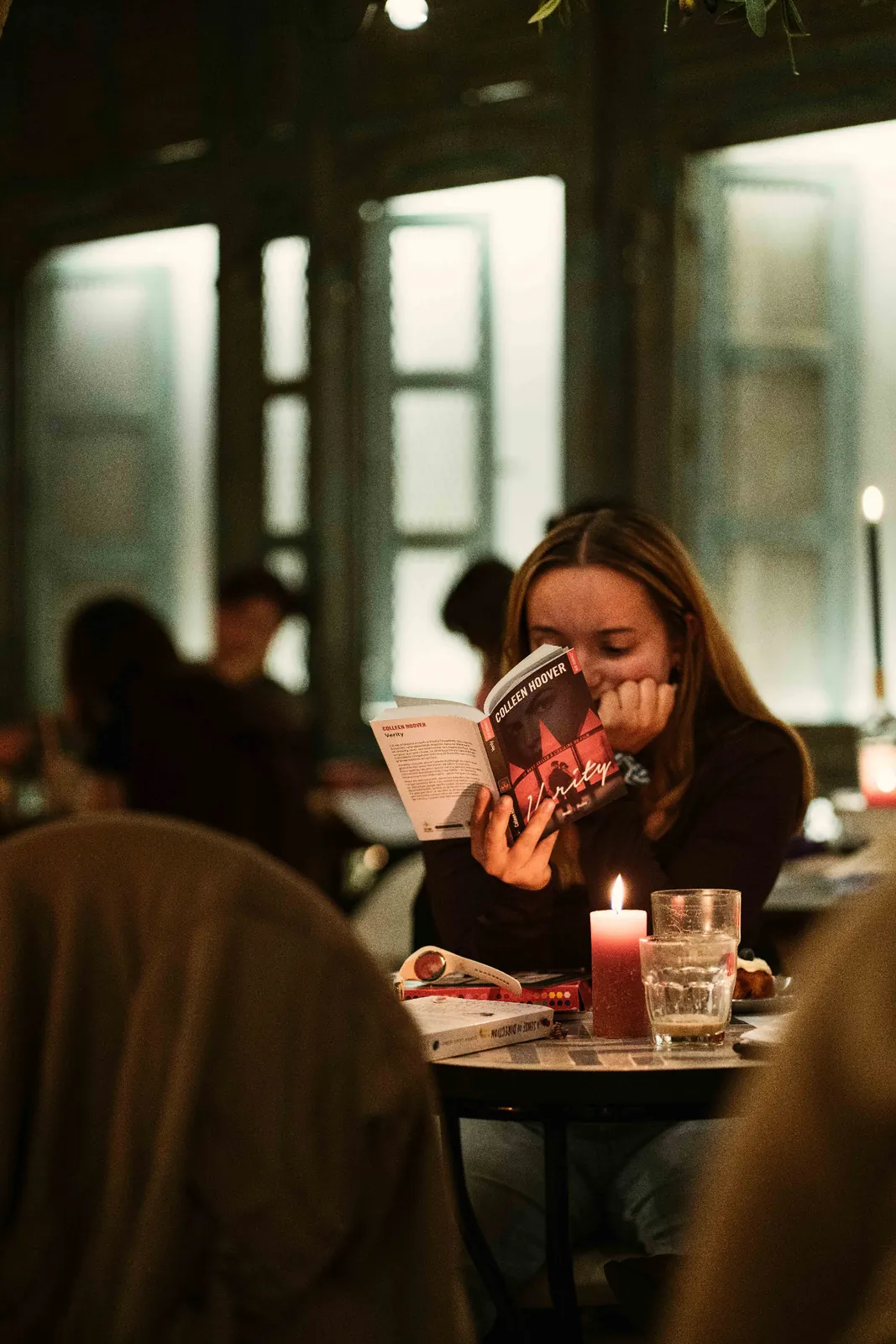 A participant reads at a candlelit table.
